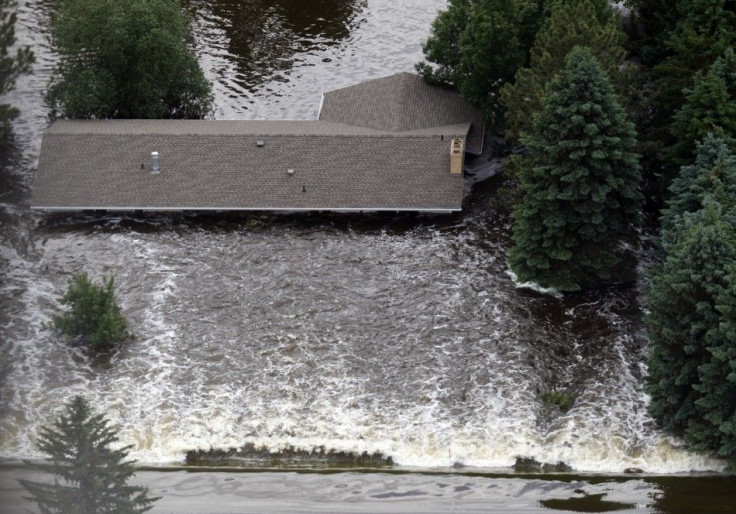 Strong water currents hit a house in Minot, North Dakota, as the Souris River spills over levees and dikes