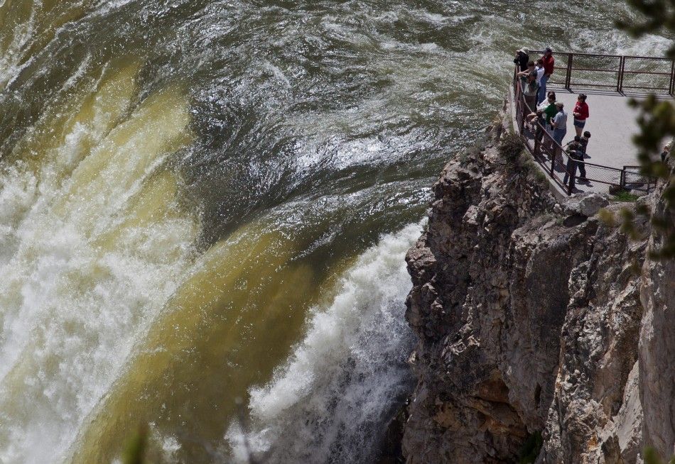 People stand at the brink of the 93-meter tall Yellowstone River Lower Falls in Yellowstone National Park