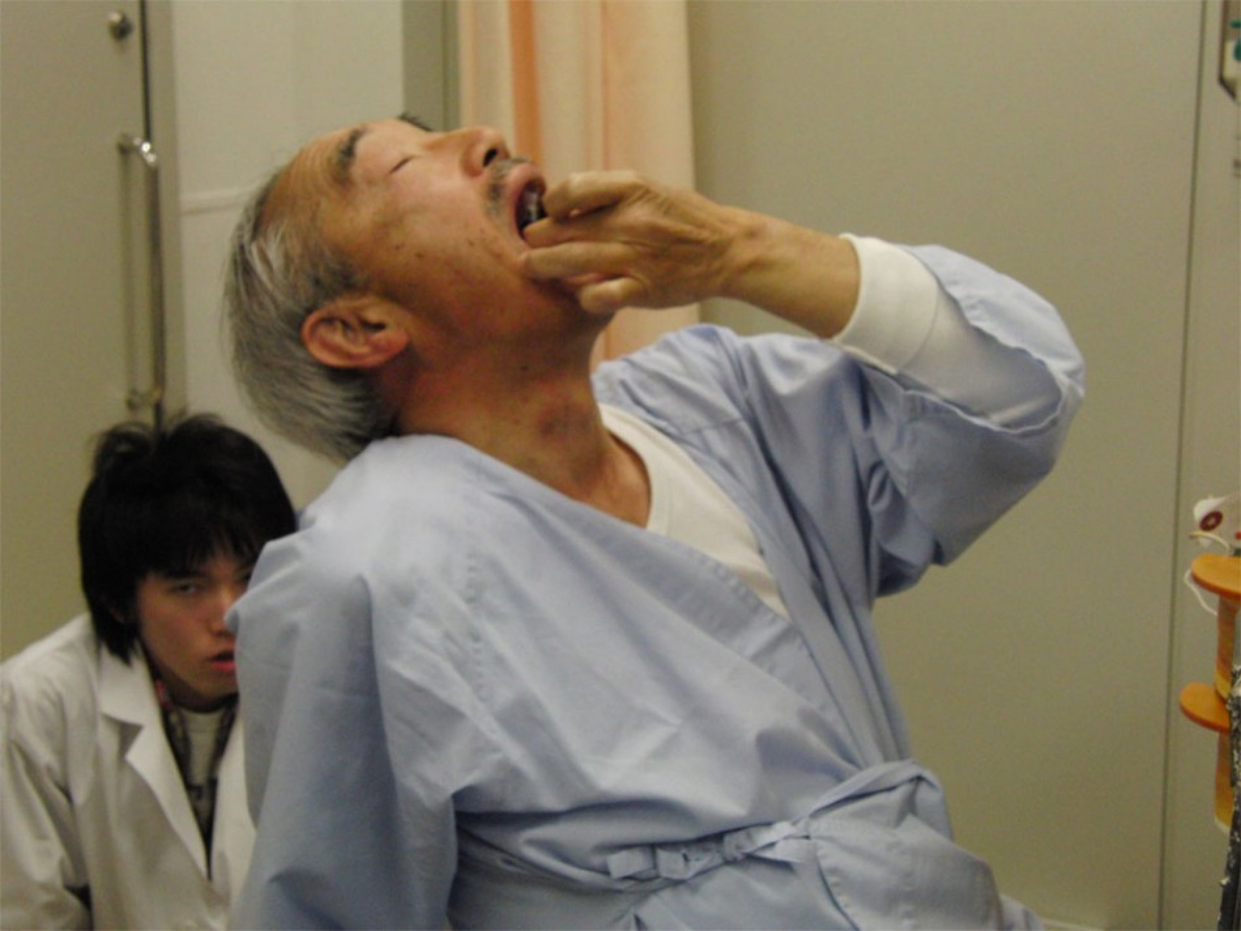 Naotake Otsuka, professor emeritus of Ryukoku University and CEO of Mu Ltd is seen swallowing the Mermaid pill