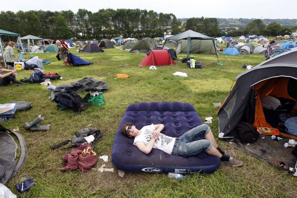 A festival goer sleeps on an inflatable matress before leaving Worthy Farm and the Glastonbury Festival inSomerset June 27, 2011.
