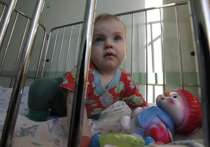 Baby sits in crib