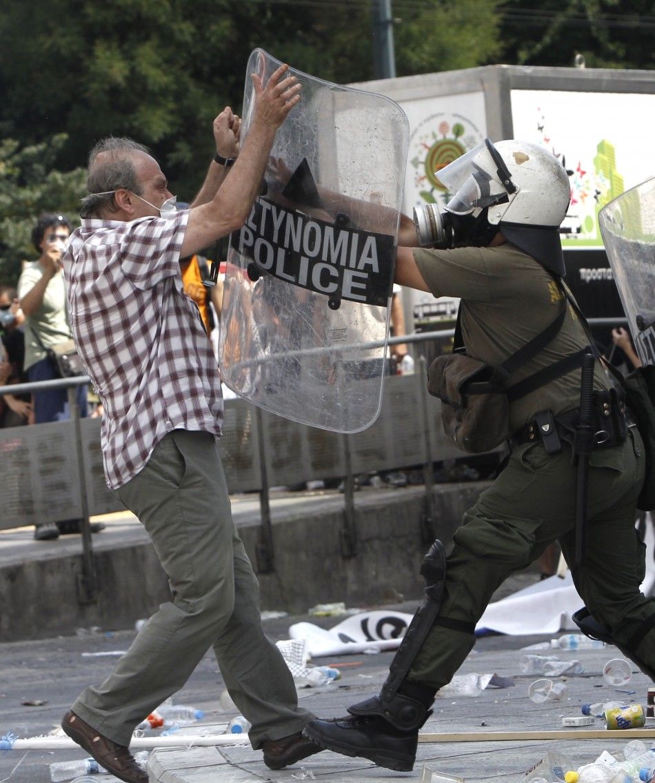A demonstrator confronts a riot policeman during protests against austerity measures in Athens