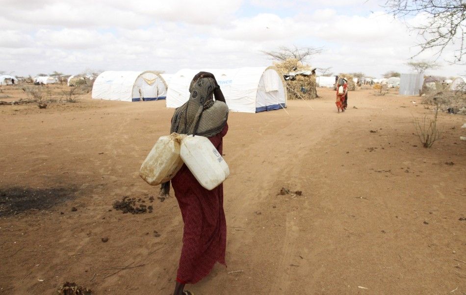 A Somali refugee carries jerry-cans of water from a tap at the Dagahaley camp in Dadaab