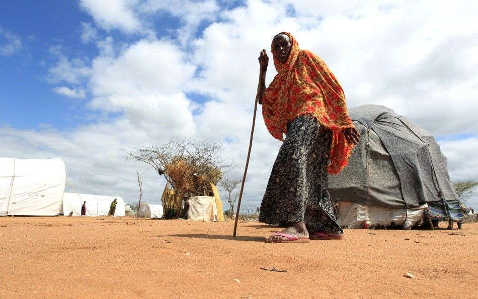 A Somali refugee woman who just arrived at the Dagahaley camp, walks past makeshift shelters, in Dadaab