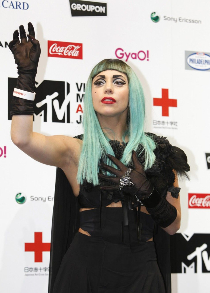 Lady Gaga waves during a news conference in Tokyo
