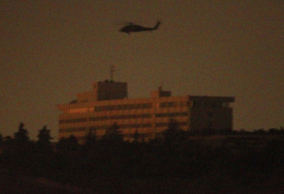 A NATO helicopter flies above the Intercontinental hotel in Kabul