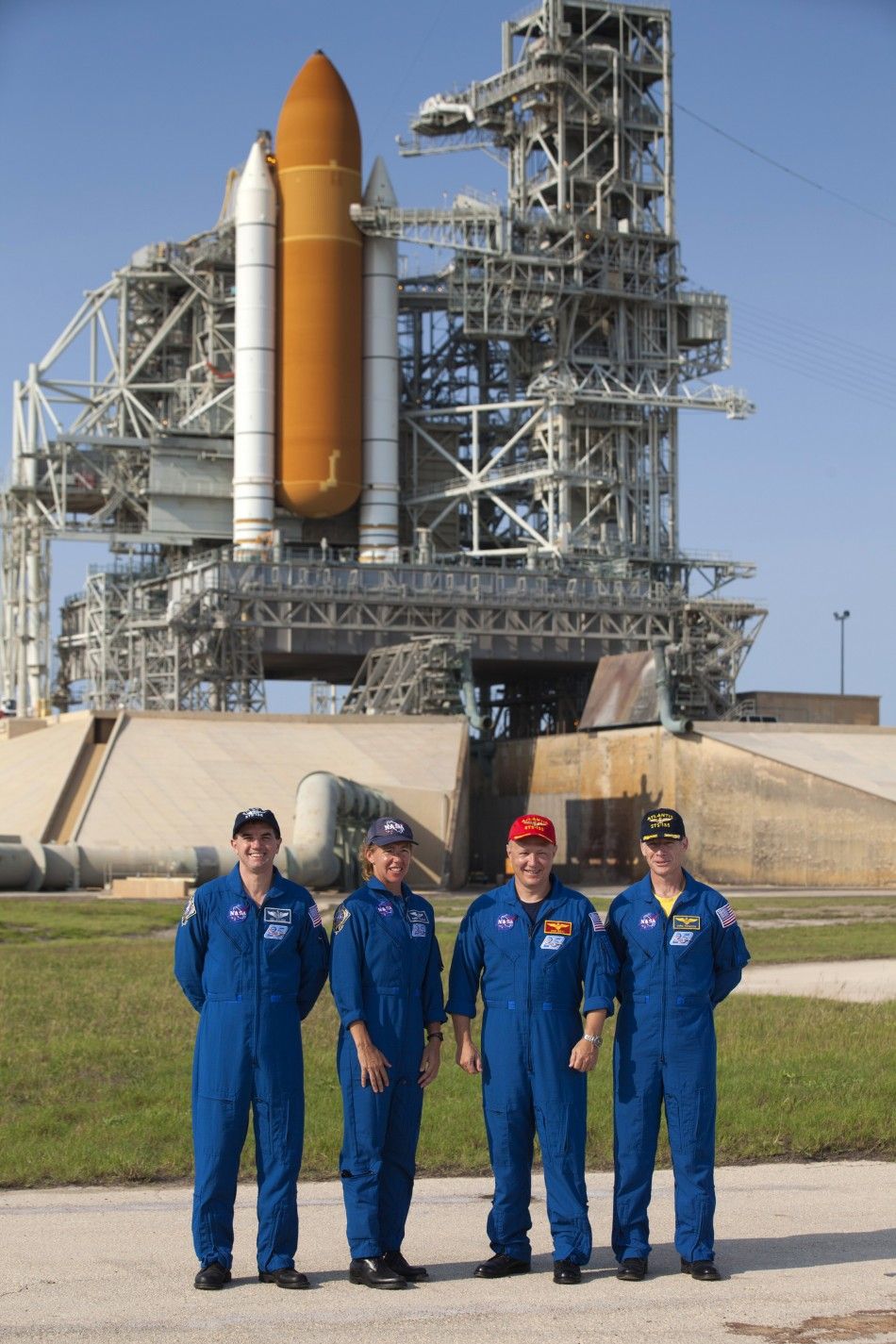 Space shuttle Atlantis STS-135 L to R mission specialist Rex Walheim, mission specialist Sandra Magnus, pilot Douglas Hurley and commander Christopher Ferguson pose for a photo in the flame trench of launch pad 39A at the Kennedy Space Center in Cape Ca