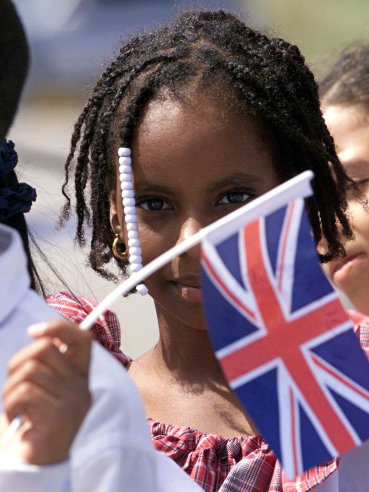 Jamaican children wave flags as they await [Britain&#039;s Queen Elizabeth] at Montego Bay&#039;s Airport,