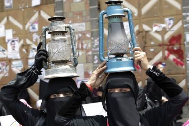 Women carry kerosene lamps to protest against power outages during a demonstration to demand the ouster of Yemen&#039;s President Ali Abdullah Saleh in Taiz