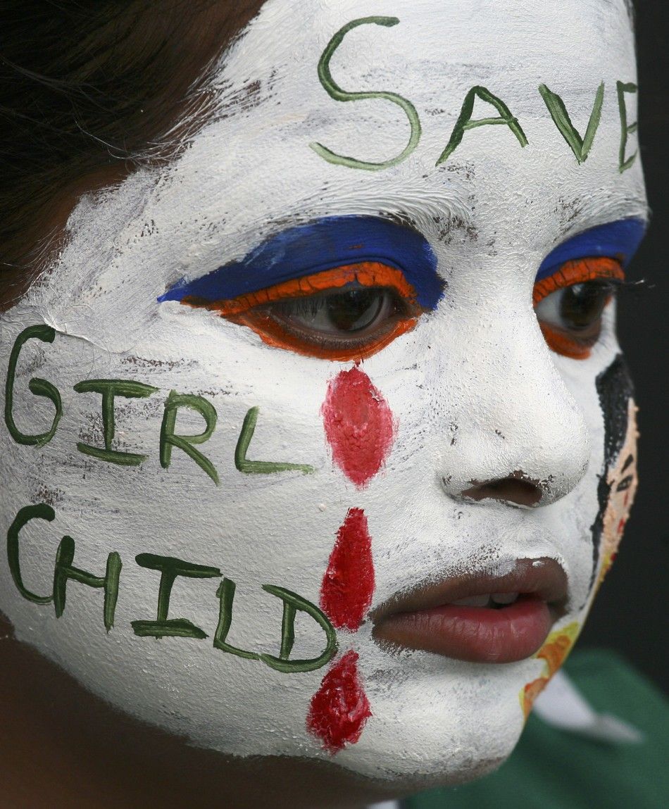A girl with her face painted with an awareness message on female foeticide