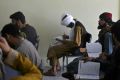 A member of the Taliban (C) attends an economic faculty class at a private university in Kabul