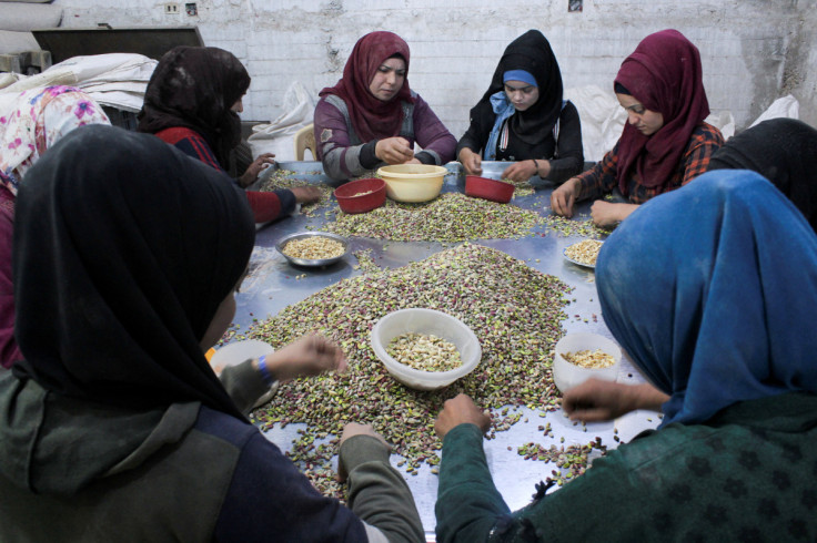 Women sort pistachios at a factory in the town of Morek