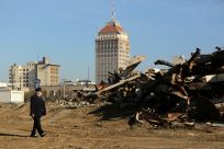 A man walks past a building that was razed to make way for the California High Speed Rail in Fresno