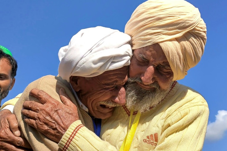 Indian Sikh labourer Sika Khan (R) tearfully embraces his elder brother Sadiq Khan from Pakistan near the border at the Kartarpur corridor