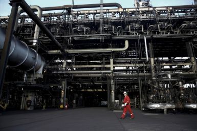 An oilfield worker walks next to pipelines at PDVSA's Jose Antonio Anzoategui industrial complex in the state of Anzoategui