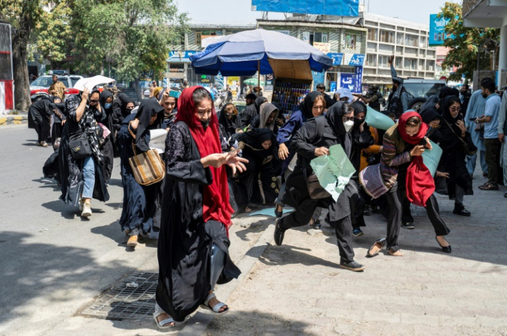 Women protesters flee as Taliban fighters fire their guns in the air at a rally in Kabul