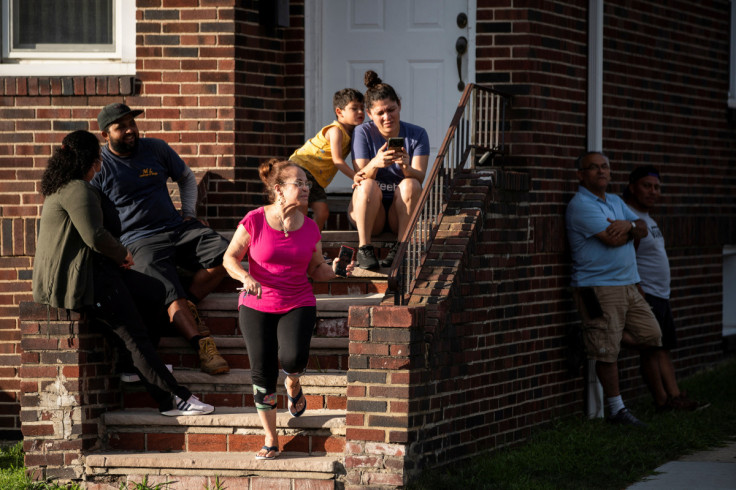 Residents try to take a look while New Jersey Police officers search the building where alleged attacker of Salman Rushdie, Hadi Matar, lives in Fairview