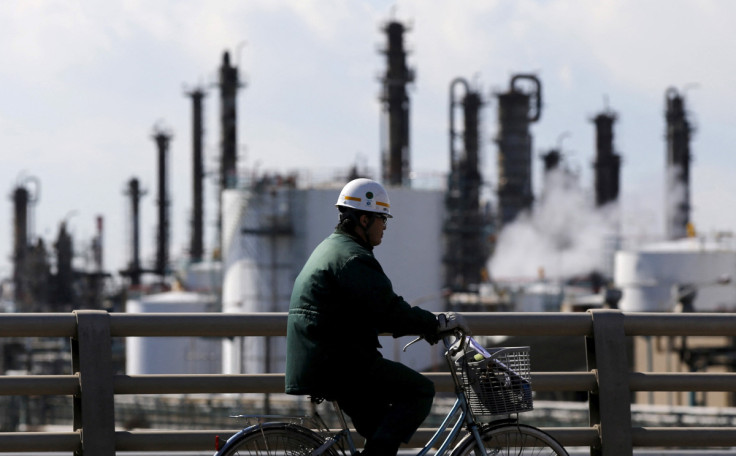 Worker cycles near a factory at the Keihin industrial zone in Kawasaki