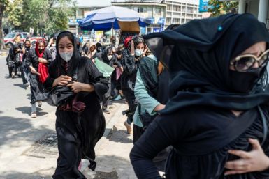 Women run for cover after Taliban fighters beat them and fired into the air to disperse a protest march called to demand their rights