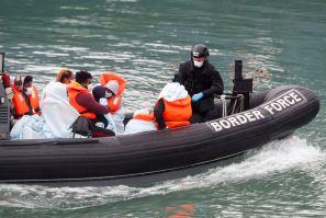 Border Patrol agents bring migrants into Dover harbour on a boat, in Dover