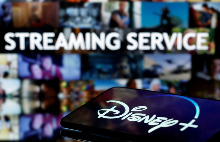 A smartphone screen showing the "Disney+" logo is seen in front of the words "streaming service" in this illustration