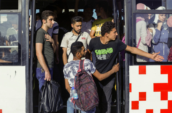 Passengers ride in a packed public transportation bus in Damascus