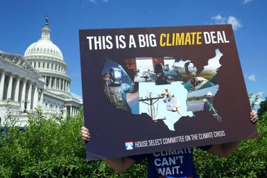 A placard is held during a climate crisis and Inflation Reduction Act press conference at the U.S. Capitol in Washington