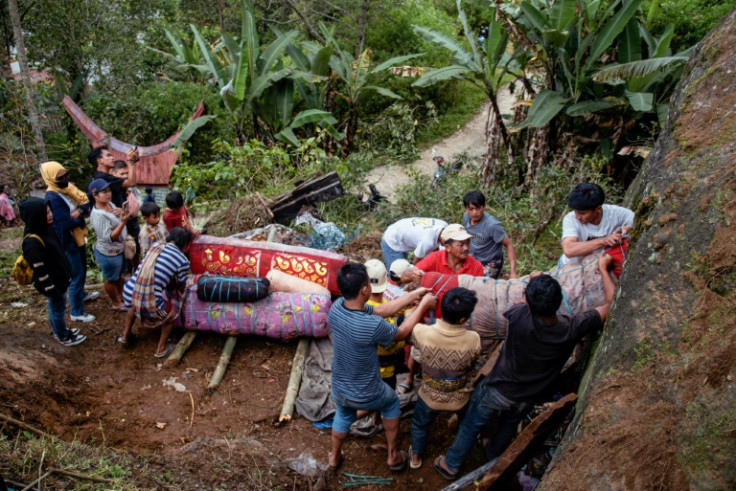 Coffins holding the preserved bodies of Indonesians' loved ones are pulled from a burial cave carved into the mountainside