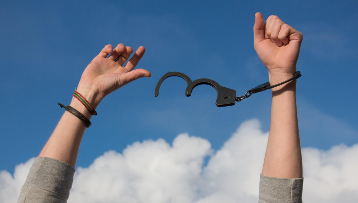 A Man Breaking Free From His Handcuffs