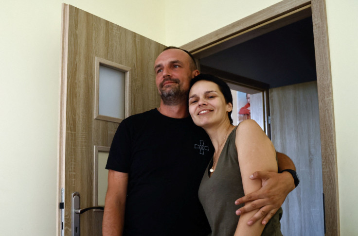 Ukrainian soldier Dovzhenko, 41 holds his wife Aleksandra during an interview for Reuters at his home in Wroclaw