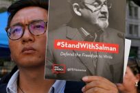 Supporters wield signs promoting freedom of speech at a rally after Salman Rushdie's attack