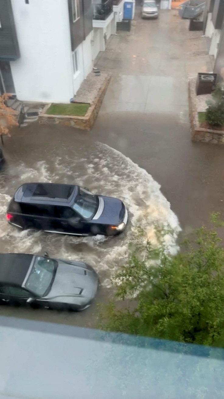 A car drives through a flooded street in Fort Worth, Texas