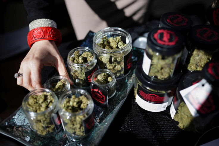 An employee puts down an eighth of marijuana after letting a customer smell it outside the Magnolia cannabis lounge in Oakland