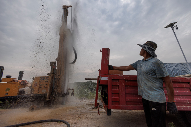Head of a drilling crew Gao Pucha watches as his drill hits water as the region experiences a drought outside Jiujiang city