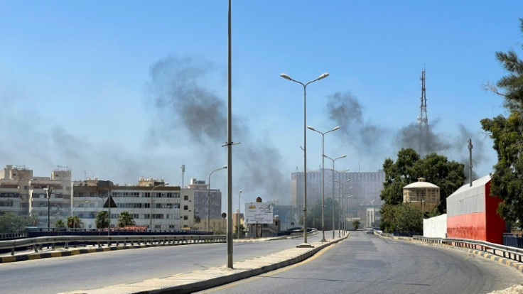 Smoke billows as rival Libyan groups exchange fire in the capital Tripoli