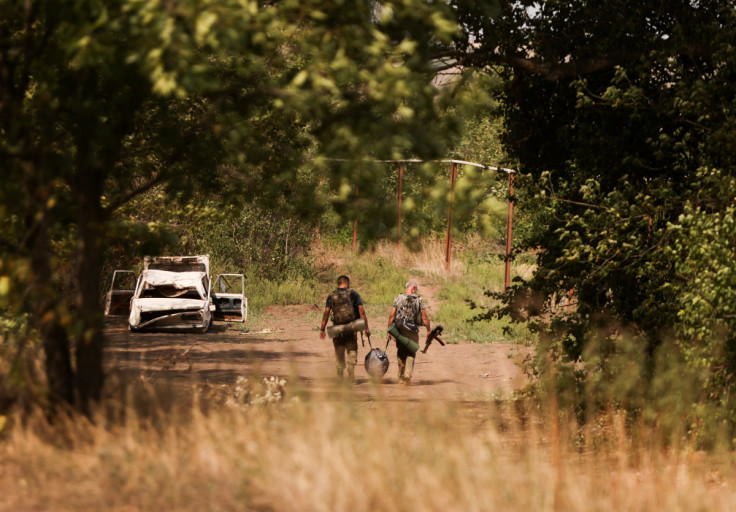 Ukrainian servicemen patrol following recent Russian shelling in Vasiukivka