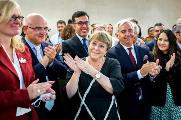 Outgoing UN High Commissioner for Human Rights Michelle Bachelet (C) is greeted at the United Nations in Geneva in August 2022