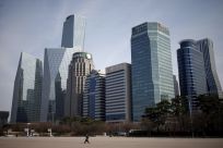 A man walks in a park at a business district in Seoul