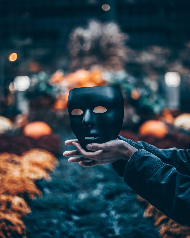 Person holding a black mask