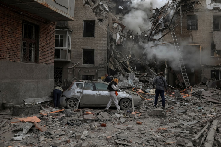 Penduduk setempat melihat puing-puing bangunan tempat tinggal yang rusak akibat serangan militer Rusia di Kharkiv