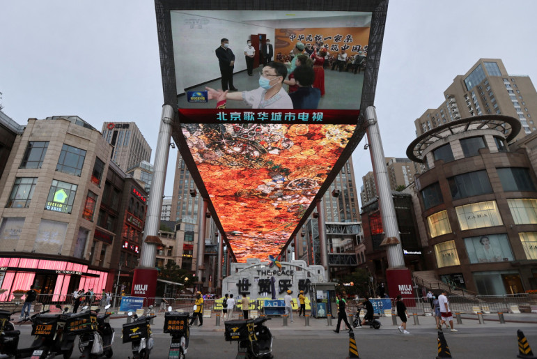 Screen shows news footage of Chinese President Xi Jinping visiting Xinjiang Uyghur Autonomous Region