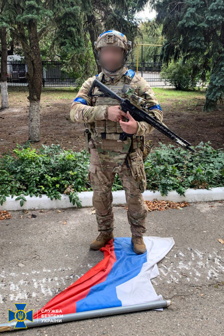 Ukrainian service member stands on a Russian national flag in unknown location in Eastern Ukraine