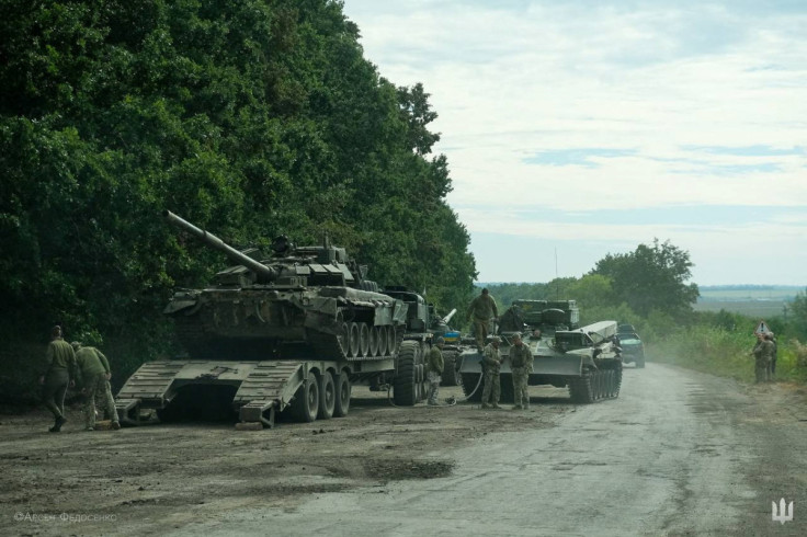 Ukrainian service members prepare to transport a Russian tank captured during a counteroffensive operation in Kharkiv region