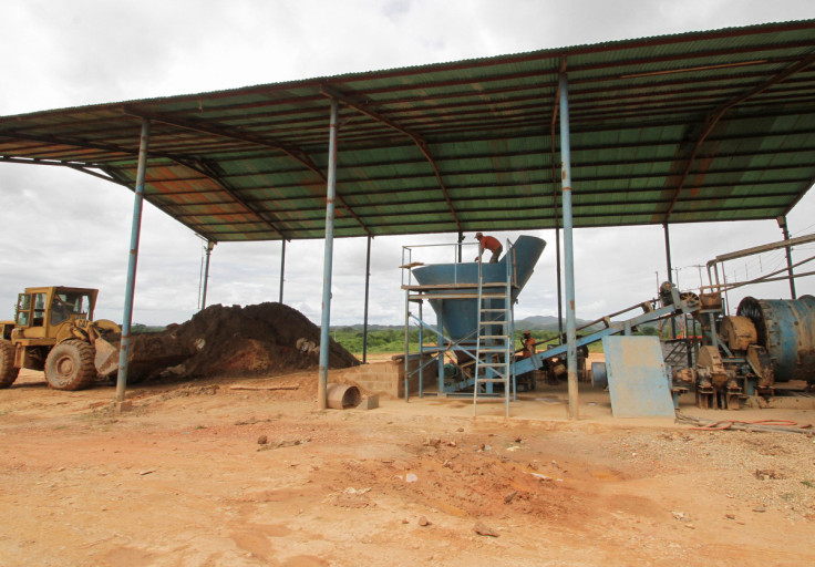 Workers process gold-bearing sand at a gold mill, in El Callao