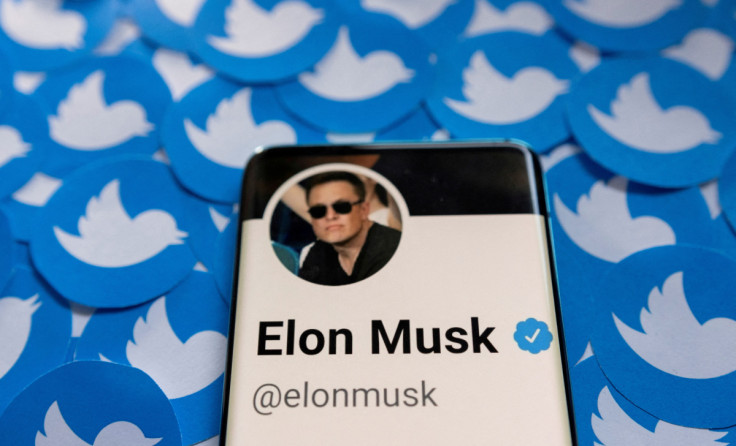 Illustration shows Elon Musk's Twitter profile on smartphone and printed Twitter logos