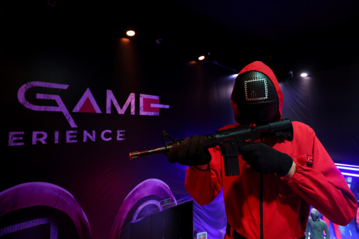 An employee, dressed as a character from the popular television series "Squid Game", stands guard with a toy gun during a Squid Game challenge, in Riyadh