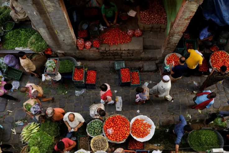 People shop at a crowded wholesale vegetable market after authorities eased coronavirus restrictions, following a drop in COVID-19 cases, in the old quarters of Delhi