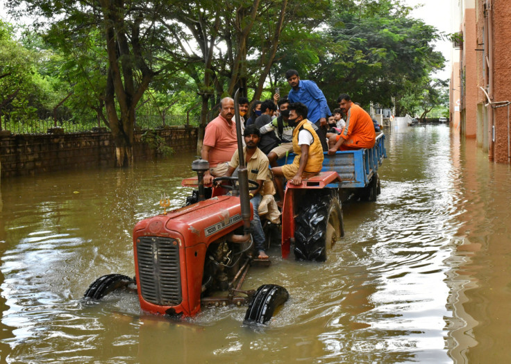Residents are evacuated to safer places in a tractor trolley after heavy rains caused flooding in a residential area in Bengaluru