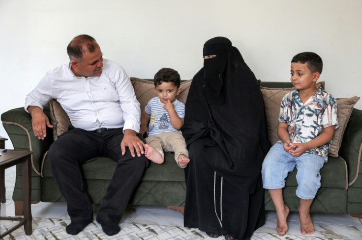 Moatassem Abdel Sater, a 42-year-old former inmate at Sednaya prison, accompanied by his child Othman, gives an interview at his home in Turkey