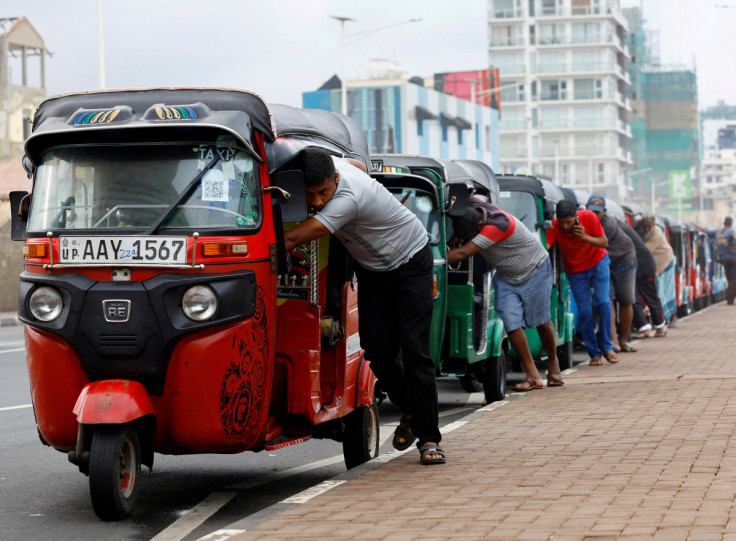 Drivers push auto rickshaws in a line to buy petrol from a fuel station, amid Sri Lanka's economic crisis, in Colombo